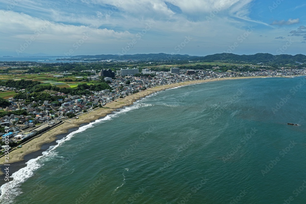 Obraz premium Aerial drone photo of coastline with sandy beach and residential area in Miura, Kanagawa, Japan