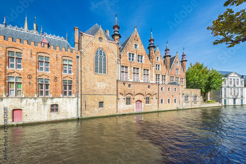 Bruges town in Belgium, Europe. Historic European city canal with traditional architecture under a vibrant blue sky, reflecting classic urban charm and aquatic beauty