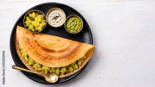 South Indian Masala Dosa Platter with Potato Filling, Chutneys, and Brass Bowls on Black Plate Flat Lay