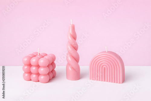 Candles in various shapes and sizes, all lit up.