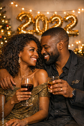 A man and woman toasting champagne glasses during New Year's Eve, embraced in a joyful moment.