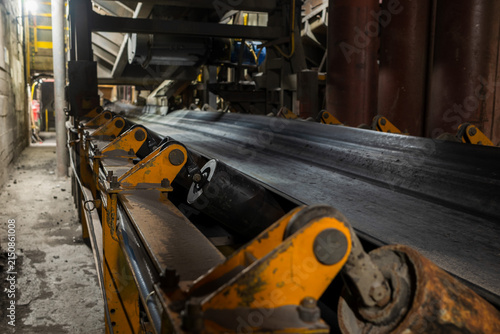 Industrial conveyor belt transporting ore inside a copper mine, showcasing heavy machinery, mining infrastructure and material handling technology in an underground industrial environment.