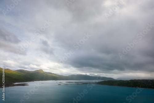 Dramatic landscape view of Tyinholmen lake and distant mountains and clouds, Norway