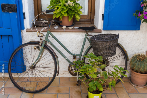 Vintage bicycle by blue doors on rustic patio