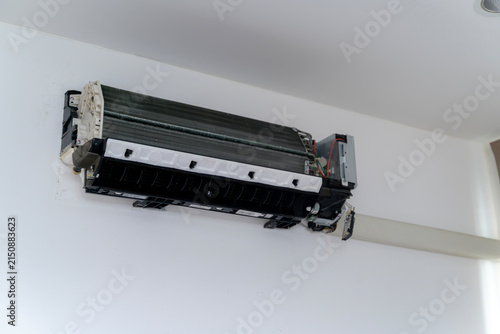 A professional HVAC technician cleans and services an indoor air conditioner unit in a residential house.