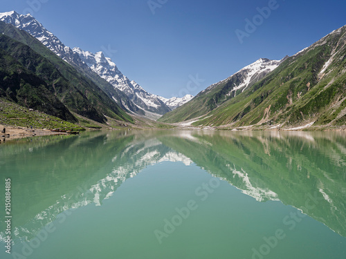 Colorful landscape view of Saiful Muluk lake with reflection of snowcapped mountains in water near Naran, Kaghan valley, Khyber Pakhtunkhwa, Pakistan