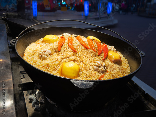 Quadro su tela Aromatic pilaf is fried in a cauldron