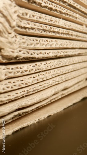 MACRO: Camera moves along a pile of cardboard on a black surface