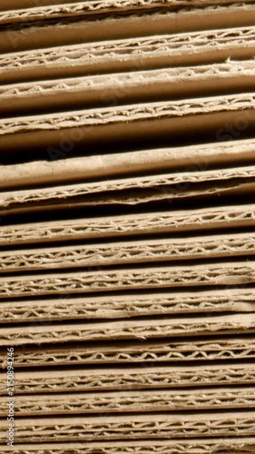 MACRO: Stack of cardboard sheets fall, slow motion