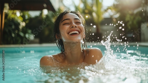 Woman laughing joyfully in a refreshing pool.