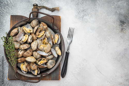 Foto Steamed vongole mollusks in round pan on gray surface