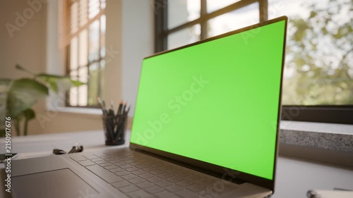 Laptop PC with Green Screen on Office Desk in Sunny Room - Perspective View