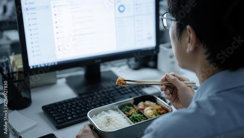 Focused Employee Enjoying Lunch While Working in Modern Office