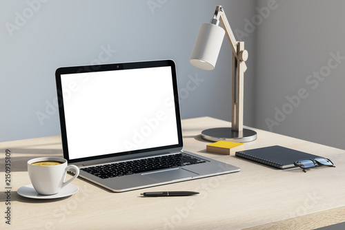Fotografía Blank laptop screen on a clean office desk with lamp, coffee, notebook, and copyspace for modern workspace branding design