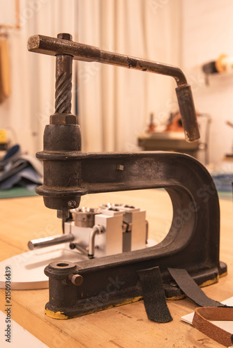 vintage manual press on a wooden workshop workbench
