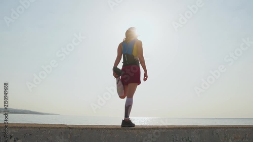 Sunrise glows behind a woman stretching on the beach. Three keyframes show back, side, and full-body views. She wears a blue top and red shorts. Calm waters stretch toward the distant horizon