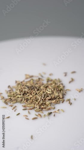 Close Up of Fennel Seeds Falling onto a White Surface, Highlighting Culinary Herbs, Spices, and Organic Ingredients for Cooking