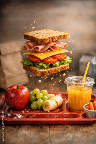 A wholesome, colorful platter featuring gourmet sandwiches and a variety of fruits.