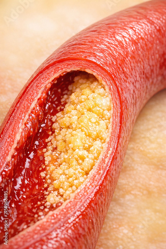 Vibrant red heart-shaped food, made from a combination of a sweet dough and filled with sesame seeds.