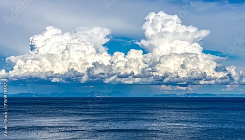 Majestic cumulus clouds over tranquil ocean horizon