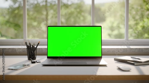 Laptop with Green Screen Mockup on Desk in Minimalistic Office Interior - Front View