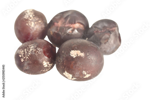 Spoiled plums are covered with mold spots. The fruit appears rotten and unfit for consumption.