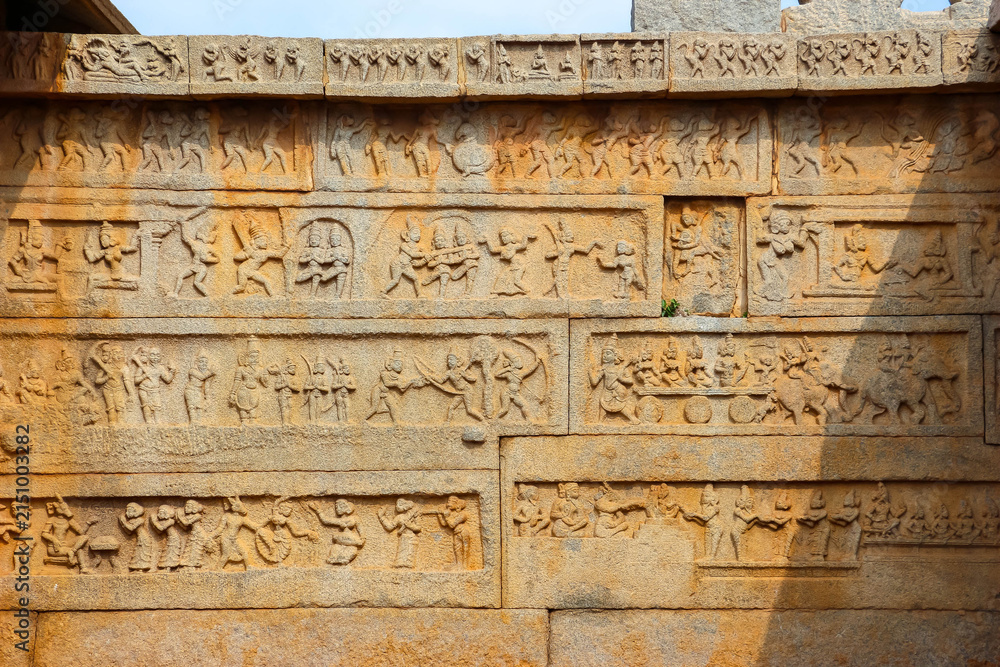 Fototapeta premium Ancient stone temple ruins and historic carved architecture in Hampi, India. Beautiful landscape with archaeological site, cultural heritage landmark and popular international tourist destination.