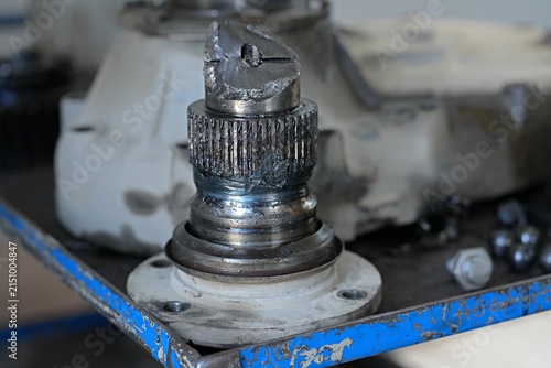 A damaged, broken metal splined shaft from heavy equipment, close-up.