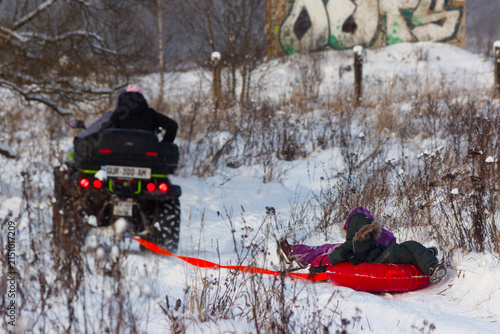 Canvas Print Exciting winter scene with kids enjoying a thrilling snow tubing ride pulled by