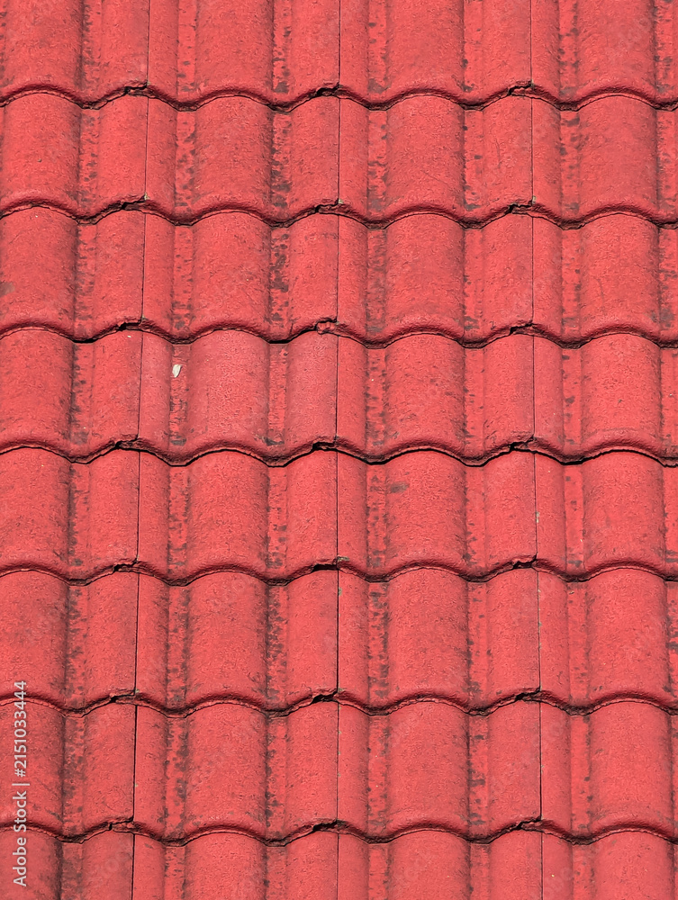 A textured pattern of red wave ceramic roof tiles creates an architectural corrugated surface background for house design.