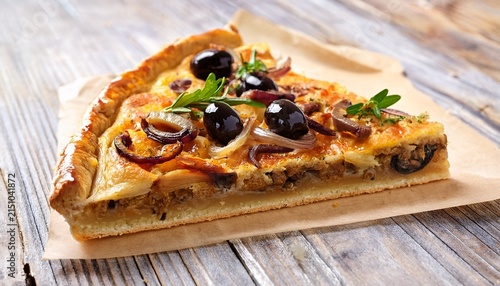 slice of traditional french pissaladiere tart with caramelized onions anchovies and black olives