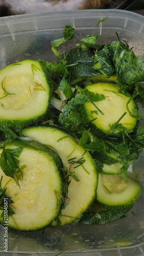Fresh marinated zucchini slices with dill in plastic food container