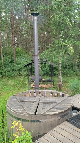 Wood fired hot tub in peaceful forest surrounded by lush greenery