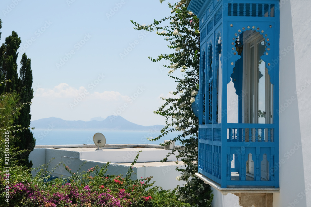 Fototapeta premium White Building with Blue Shutters and Bougainvillea in Mediterranean Town