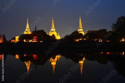 pagoda of Wat Phra Si Sanphet or temple of the holy, splendid Omniscient reflection on water with electric lamp in night