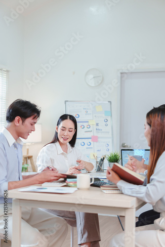 Asian business team working together in a bright modern office meeting room
