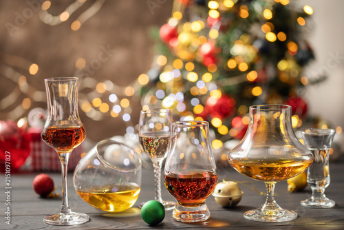 Fotografie Assortment of strong alcoholic beverages in glasses on a Christmas background
