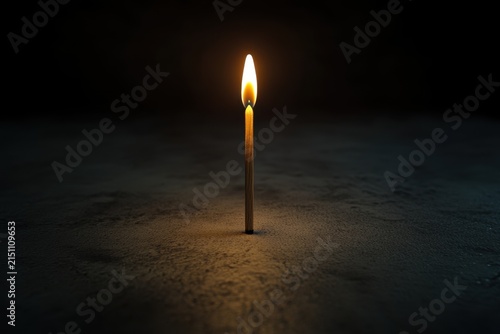 Lit wooden matchstick dark background minimal still life single flame vertical match isolated object warm light copy space