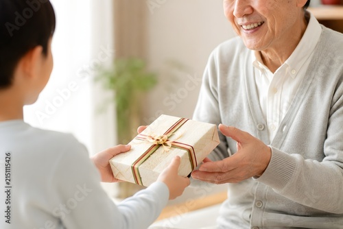 孫から祖父へプレゼントを手渡す敬老の日の感謝素材
