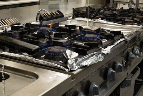 Принти на полотні Commercial gas cooking range with blue flame burners in professional restaurant