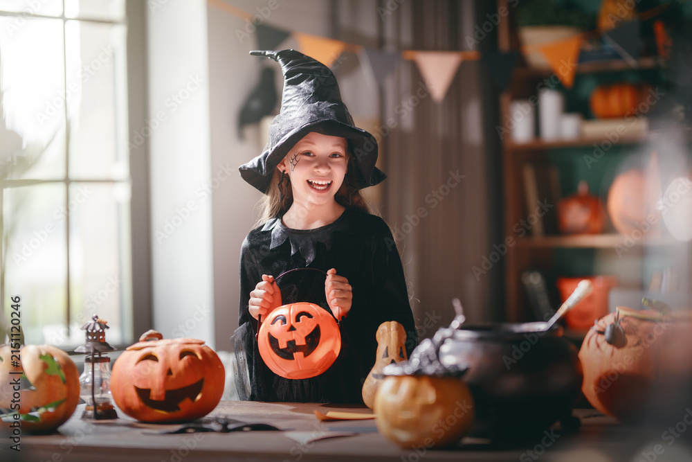 Obraz premium Smiling Child Dressed as Witch Celebrating Halloween