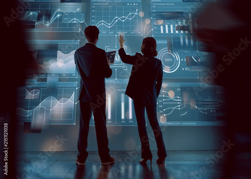 Business Professionals Analyzing Data on Futuristic Interactive Display