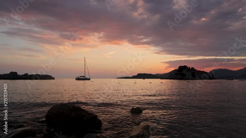 progressive sunset over the sea with boats and distant landforms in a wide-angle shot, peaceful and serene ocean view for travel and nature relaxation content. orange and pink hues.