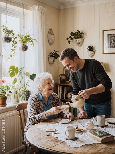 Grandmother and grandson pouring tea at wooden table laughing together in cozy home
