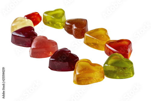 Assorted heart-shaped fruit jelly sweets arranged in a circular pattern on white background
