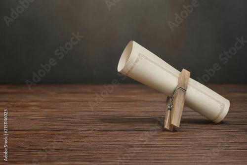 Rolled certificate is clipped with a wooden clothespin. Space for text.