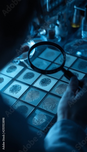 A forensic investigator examining diverse fingerprint impressions with a magnifying glass,