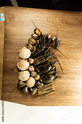 Obraz na płótnie Fresh seafood displayed on a wooden table featuring various shellfish and crusta