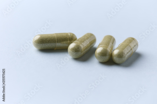 Barley grass capsules. Antioxidants. Concept for a healthy dietary supplementation. Bright background. Soft focus. Close up. Copy space.