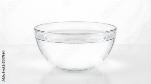Clear glass bowl filled with clean water isolated on white background.